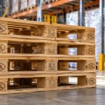 Medidas del palet europeo: dimensiones, peso y carga máxima Palets europeos EPAL de madera apilados junto a una transpaleta en un almacén logístico